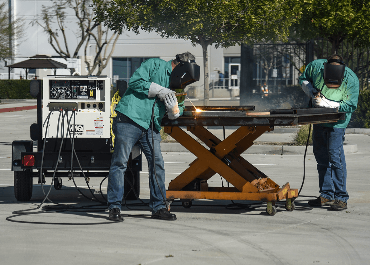 Photo of worker welding outside